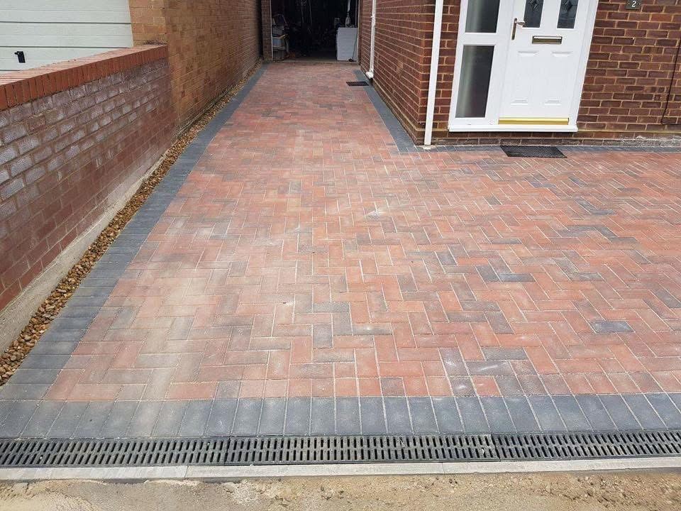 Red brindle block paving driveway with charcoal border and drainage channel