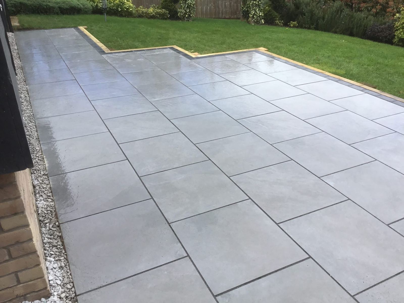 Large grey porcelain patio overlooking lawn